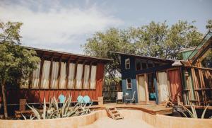 una casa con un patio y una casa con un cobertizo en Uber Unique Lakefront Eco Cabin on a Magical Retreat Property en Spicewood