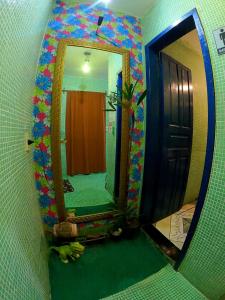 a bathroom with a mirror and a green floor at Hostel Uai in Ouro Preto