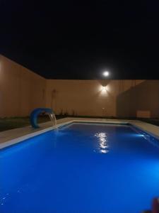 a swimming pool at night with a water fountain at La Casa de Nino in Salta