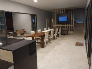 a dining room with a table and a flat screen tv at La Casa de Nino in Salta