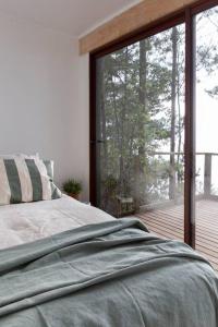 um quarto com uma cama e uma grande janela de vidro em Duerme y despierta en el Mar em Curanipe