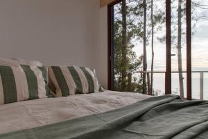 a bed in a room with a large window at Duerme y despierta en el Mar in Curanipe