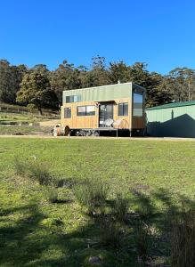 an rv parked in a field of grass at Little Pardalote Tiny Home Bruny Island in Alonnah