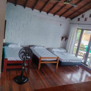 a room with two beds and a fan in it at AFRO HOSTEL in Necoclí
