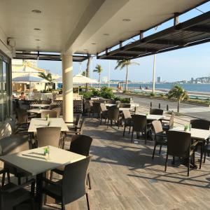 マサトランにあるOlas Altas Inn Hotel & Spaのビーチ沿いのレストラン(テーブル、椅子付)