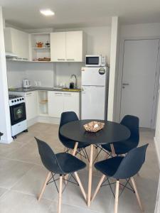 uma cozinha com uma mesa e cadeiras numa cozinha em Apartamento céntrico en Mercedes Uruguay em Mercedes