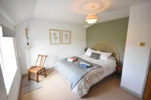 um quarto com uma cama e uma cadeira em Rural Retreat w/ Hot Tub & River, Sleeps 12 Guests em Tenbury