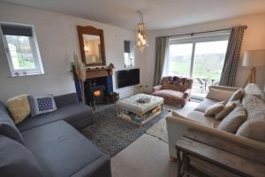 uma sala de estar com um sofá e uma cadeira em Rural Retreat w/ Hot Tub & River, Sleeps 12 Guests em Tenbury