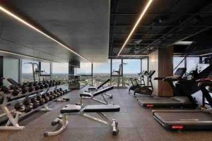 a gym with a lot of treadmills and machines at Luxury Condo w/ Ocean View, Pool, Gym near Crown in Melbourne