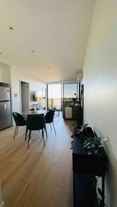 a living room with a table and chairs and a kitchen at Luxury Condo w/ Ocean View, Pool, Gym near Crown in Melbourne