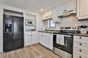 La cuisine est équipée de placards blancs et d'un réfrigérateur noir. dans l'établissement M20 Rentals Beautiful Salem NH 3bd 1ba Centrally Located, à Salem