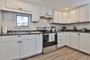 La cuisine est équipée de placards blancs, d'un évier et d'une cuisinière. dans l'établissement M20 Rentals Beautiful Salem NH 3bd 1ba Centrally Located, à Salem