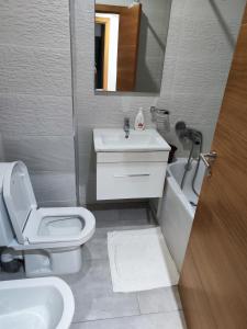 La salle de bains est pourvue de toilettes blanches et d'un lavabo. dans l'établissement Les Belles Appartements Family Only, à Tanger