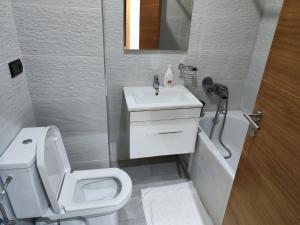 La salle de bains est pourvue de toilettes blanches et d'un lavabo. dans l'établissement Les Belles Appartements Family Only, à Tanger