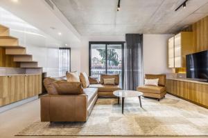 メルボルンにあるThe Bridge - Epitomising Modern Luxury by the Bayのソファとテレビのあるリビングルーム