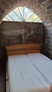 two beds in a room with a window at בית על חוף כנרת in Tiberias