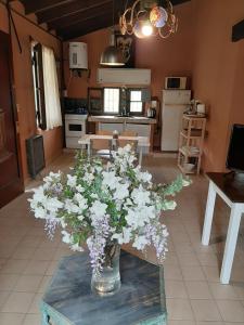 um vaso de flores em uma mesa em uma cozinha em Delta Rose Farm em Tigre