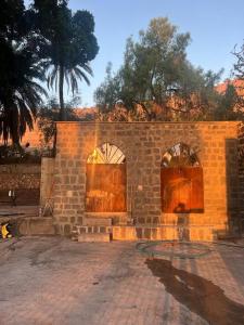 un edificio de ladrillo con dos puertas de madera. en בית על חוף כנרת, en Tiberíades