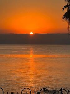 una puesta de sol sobre un gran cuerpo de agua en בית על חוף כנרת en Tiberias