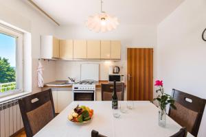 a kitchen with a table with a bowl of fruit on it at Apartments in Crikvenica 41682 in Crikvenica