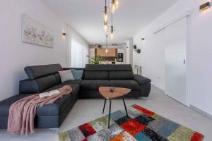 ein Wohnzimmer mit einem schwarzen Sofa und einem Tisch in der Unterkunft Holiday home in Grizane 41663 in Grižane