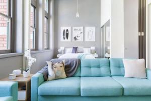 a living room with a blue couch and a bed at Inspiration Station - An Iconic Designer Pad in Melbourne