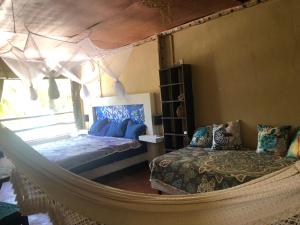 1 dormitorio con hamaca, 1 cama y ventana en Casa Lilo Mahahual - privat house en Mahahual