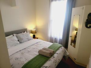 um quarto com uma cama com uma toalha em Central Victoria Oasis em Hamilton