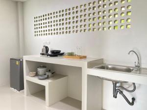 a white kitchen with a sink and a counter at De Saran Lanta in Ko Lanta