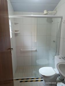 a bathroom with a shower with a toilet and a sink at Casa no Centro de Ubatuba in Ubatuba