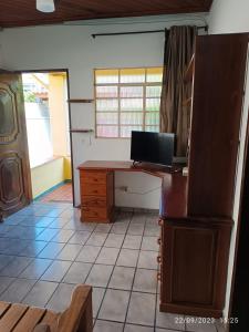 a room with a desk with a laptop on it at Casa no Centro de Ubatuba in Ubatuba