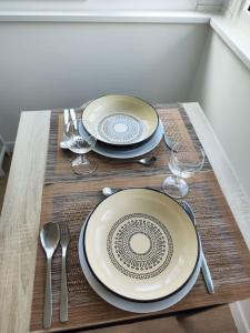 a table with two plates and wine glasses on a table at Peaceful cocoon in Chatou +7 photos