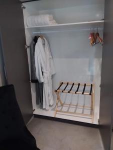 a closet with a white robe and towels at Karapiro Willows Luxury B & B in Cambridge