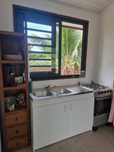 une cuisine avec deux lavabos et une grande fenêtre dans l'établissement Bungalow Moorea à 50 mètres du lagon, 