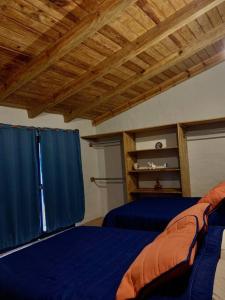 a bedroom with a blue bed and blue curtains at Casa Brisa in Tapalpa