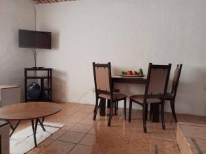 a dining room with a table and chairs and a television at Casa Brisa in Tapalpa