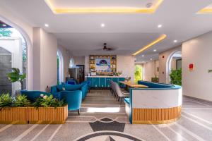 a lobby of a hospital with blue chairs and tables at Le Cap Hotel & Apartment in Da Nang