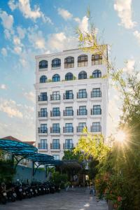 a tall white building with a lot of windows at Le Cap Hotel & Apartment in Da Nang
