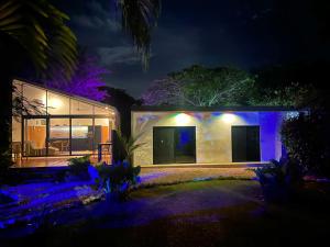 una casa de noche con luces púrpuras en Pyramid Tamarindo en Tamarindo