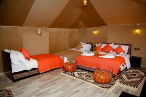 two beds in a room with pumpkins on the floor at Luxury berber style in Merzouga