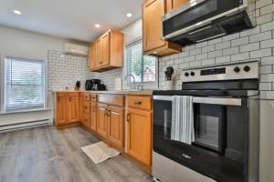 uma cozinha com armários de madeira e um forno com placa de fogão em M20 Rentals Modern Apartment 2bd 1ba Centrally Located Salem, NH em Salem