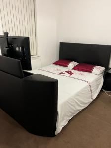 a bedroom with a bed and a chair and a television at Comfy One bedroom Apartment in London