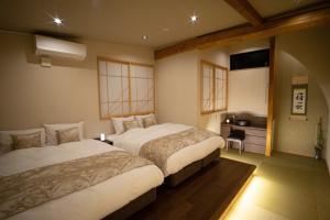 Minami-sotoborichōにあるNagoya city - House - Vacation STAY 28742vのベッド2台とテレビが備わるホテルルームです。