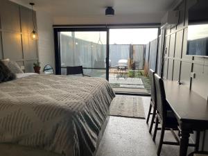 1 dormitorio con cama, mesa y balcón en Motel3858, en Heyfield