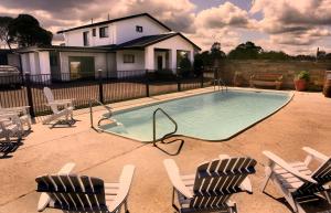 - une piscine avec deux chaises et deux chaises dans l'établissement Motel3858, à Heyfield
