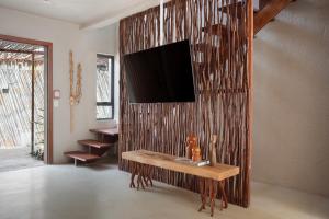 a living room with a table with a television on a wall at Kza Patacho in Pôrto de Pedras