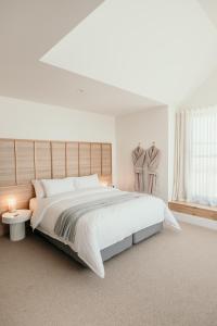 a white bedroom with a large bed and a window at The Oak & Anchor Hotel in Port Fairy