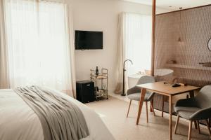 a bedroom with a bed and a table and a bathroom at The Oak & Anchor Hotel in Port Fairy