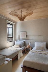two beds in a room with a ceiling at Kza Patacho in Pôrto de Pedras +38 photos