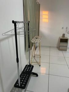 um quarto com uma cadeira e um objecto metálico em apartamento inteiro em Cuiabá